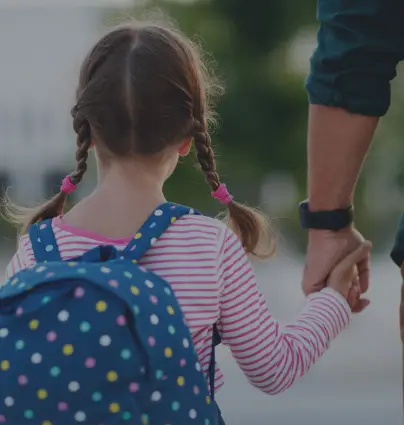 a little girl holding the hand of an adult